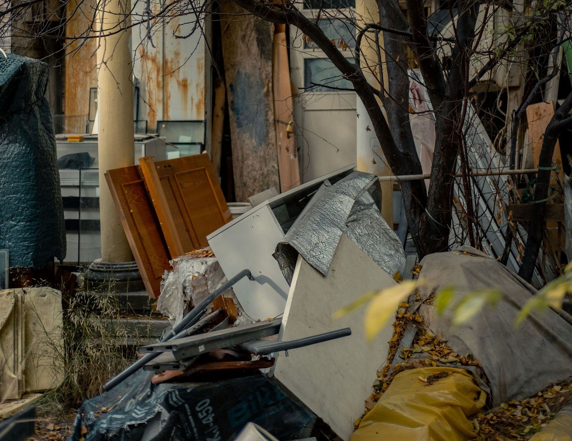 Abandoned building overgrown with trees and debris, capturing urban decay.
